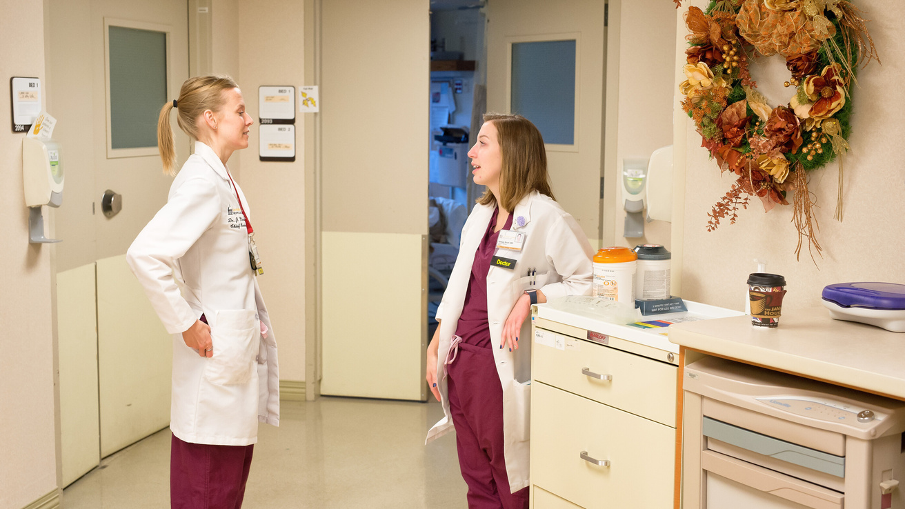 Medical students and residents, in the surgical residency training program, work under the supervision of the surgical staff as they make their rounds. Residents consulting with surgical staff.
